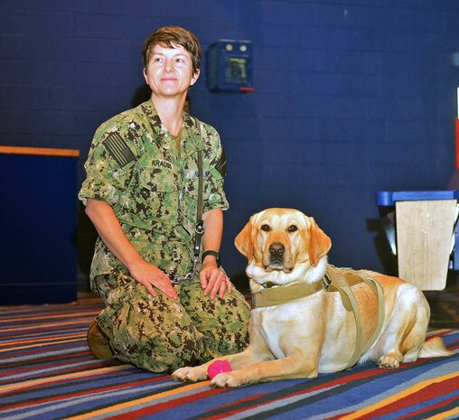 JOINT EXPEDITIONARY BASE LITTLE CREEK FORT STORY, VIRGINIA BEACH, VA (August 18, 2022) Cmdr. Tracey Krauss, officer in charge (OIC) and public health specialty Leader at Navy Medicine Readiness and Training Unit (NMRTU) Norfolk, sits on the floor alongside "Patty Mac", a facilities dog, often referred to as a stress dog, during a Professional Development (PRODEV) training at Joint Expeditionary Base Little Creek Fort Story (JEBLCFS) today. (U.S. Navy photo by Mass Communication Specialist 1st Class Marlon Goodchild)