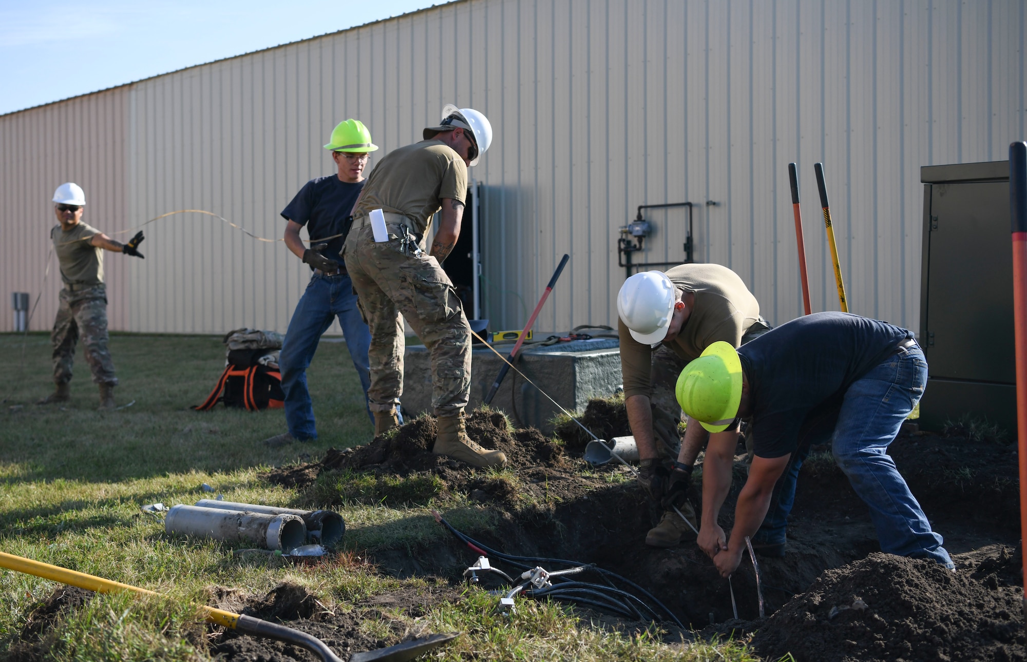 Airmen from the 319th Civil Engineer Squadron and Nodak Electric Cooperative contractors replace high-voltage electrical wiring Aug. 23, 2022, on Grand Forks Air Force Base, North Dakota. The 319th CES used the installation project as an opportunity to practice skills not used in day-to-day operations. (U.S. Air Force photo by Airman 1st Class Roxanne A. Belovarac)