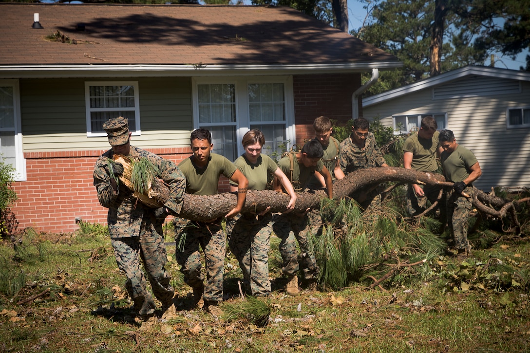 U.S. Marines assigned to II Marine Expeditionary Force Support Battalion Engineers move a large tree branch as an attempt to remove debris from a residential community aboard Camp Lejeune, N.C. caused by Hurricane Florence Sept 19, 2018. Hurricane Florence is the biggest storm to cause devastating effects to the Carolinas since 1999 with its strong winds and heavy rains. (U.S. Marines Corps photos by LCpl. Auburne D. Gipson)