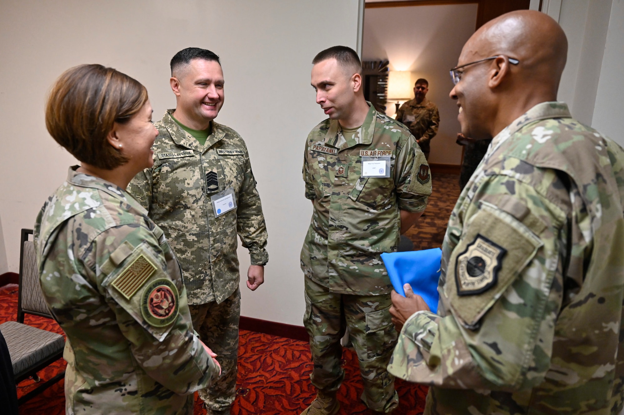 Chief Master Sergeant of the Ukrainian Air Force Kostiantyn Stanislavchuk speaks with Air Force Chief of Staff Gen. Charles Q. Brown Jr., right, and Chief Master Sgt. of the Air Force JoAnne S. Bass, left, during the Senior Enlisted Leader International Summit in Arlington, Va., Aug. 1, 2022. Master Sgt. Yuriy Papayanki, 97th Healthcare Operations Squadron medical administration technician, served as a translator and escort for Chief Stanislavchik. (U.S. Air Force photo by Eric Dietrich)