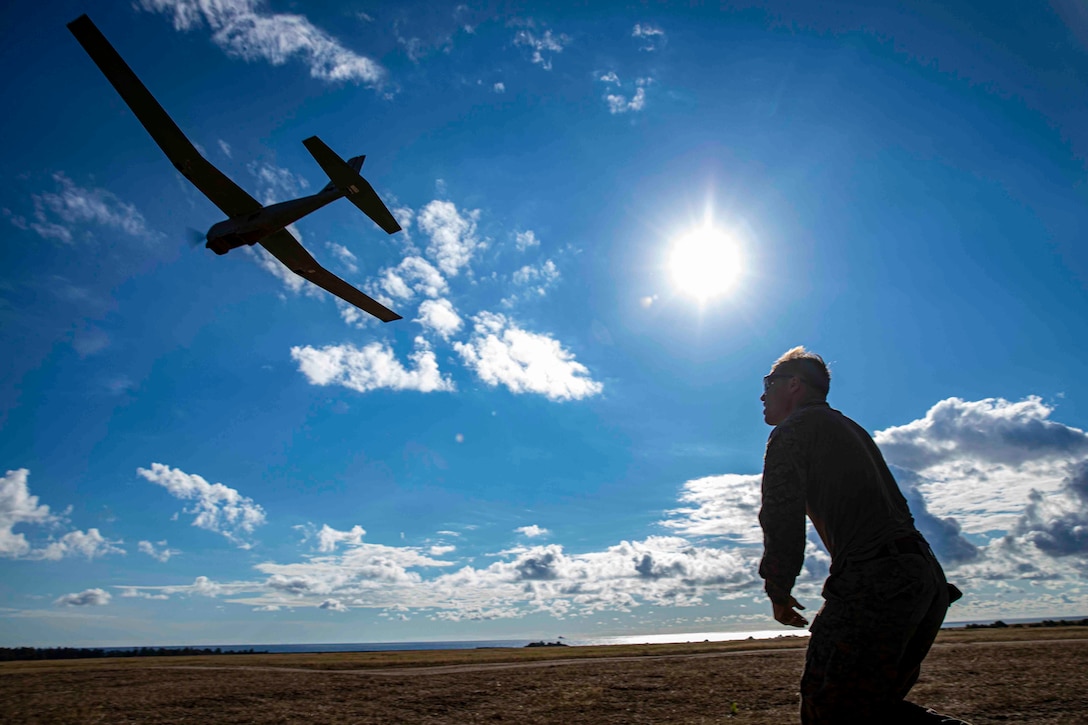 A Marine launches a small unmanned aircraft.