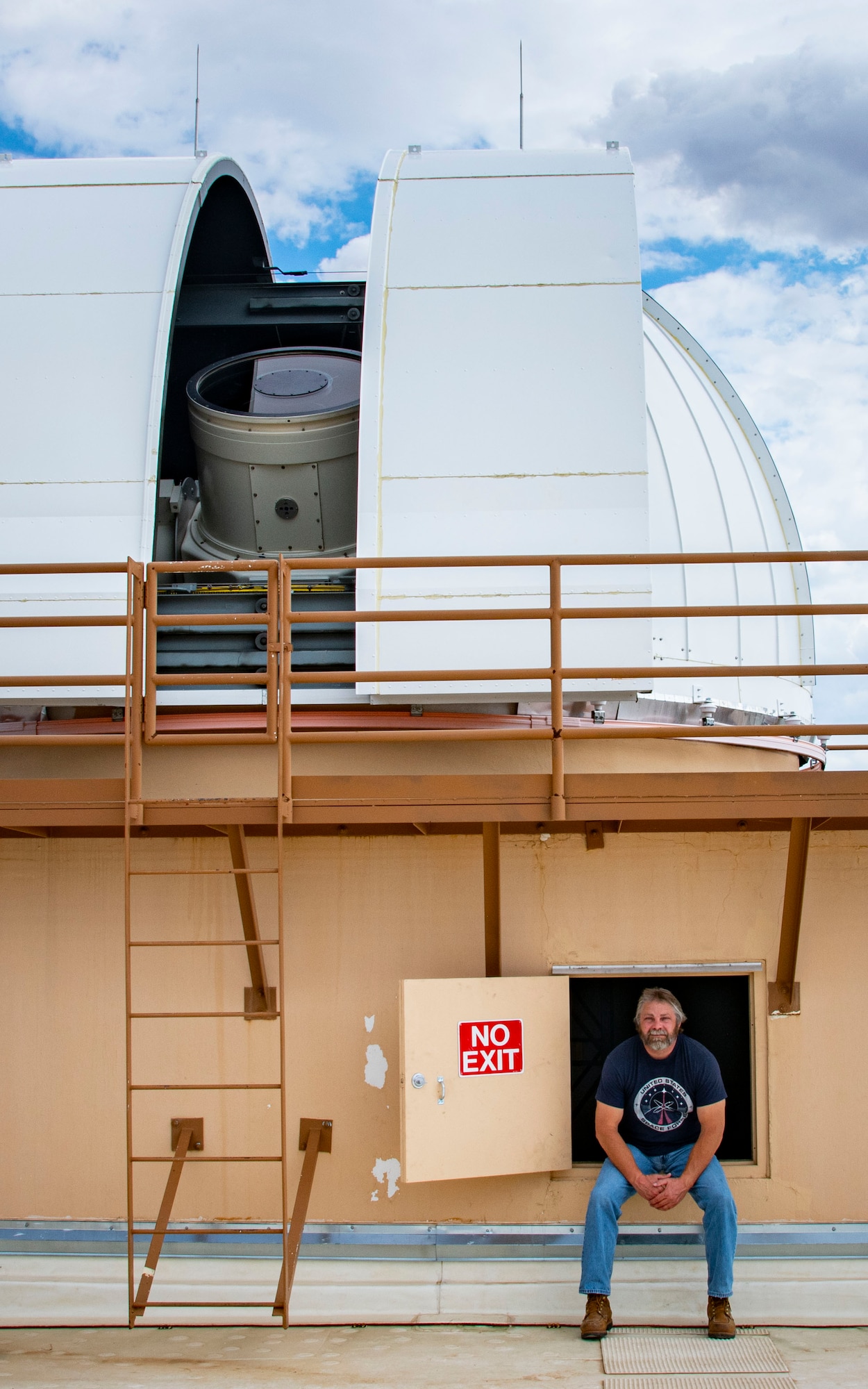 man next to telescope