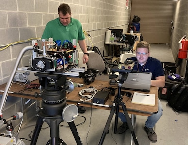 IMAGE: Naval Surface Warfare Center Dahlgren Division Scientist Graham Schattgen from the Integrated Clip-on Advanced Targeting Sight Dual Band Imager team, who support the Precision Sensing Branch, along with Luke Patrick from the Laser Weapon System Optics and Beam Control Branch work together during a laser data collection event in late May.