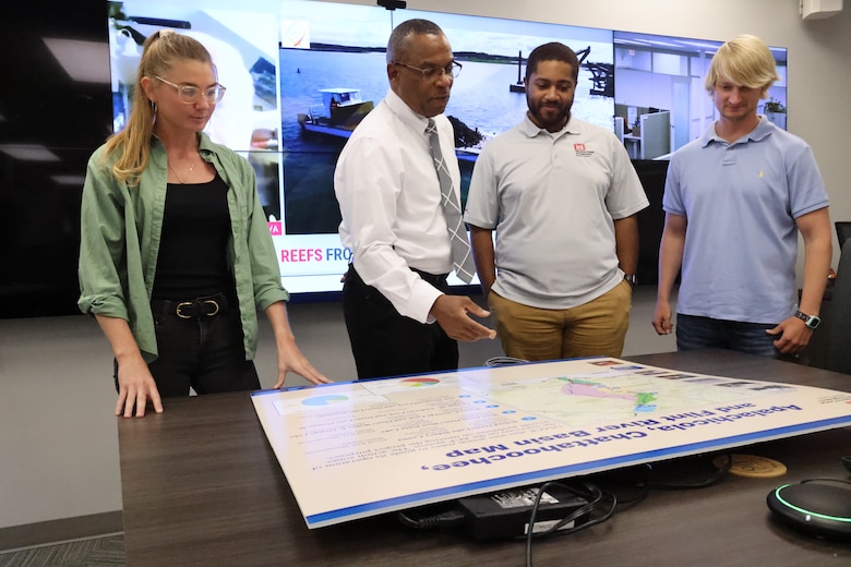 James Hathorn, U.S. Army Corps Engineers Mobile District’s Chief of the Water Management section, center, explains a water management chart to his team, on Sept. 6, 2022, in Mobile, Alabama. Hathorn, who has worked for the Corps for more than 30 years, said that he enjoys how his team works together like a family.