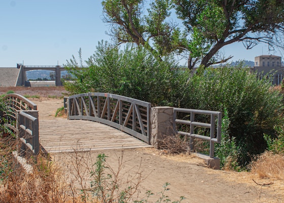 A bridged path along connects a walking trail at the Sepulveda Dam Recreational Area. The primary purpose of the dam and reservoir is flood risk management, but the project is also authorized for recreation.