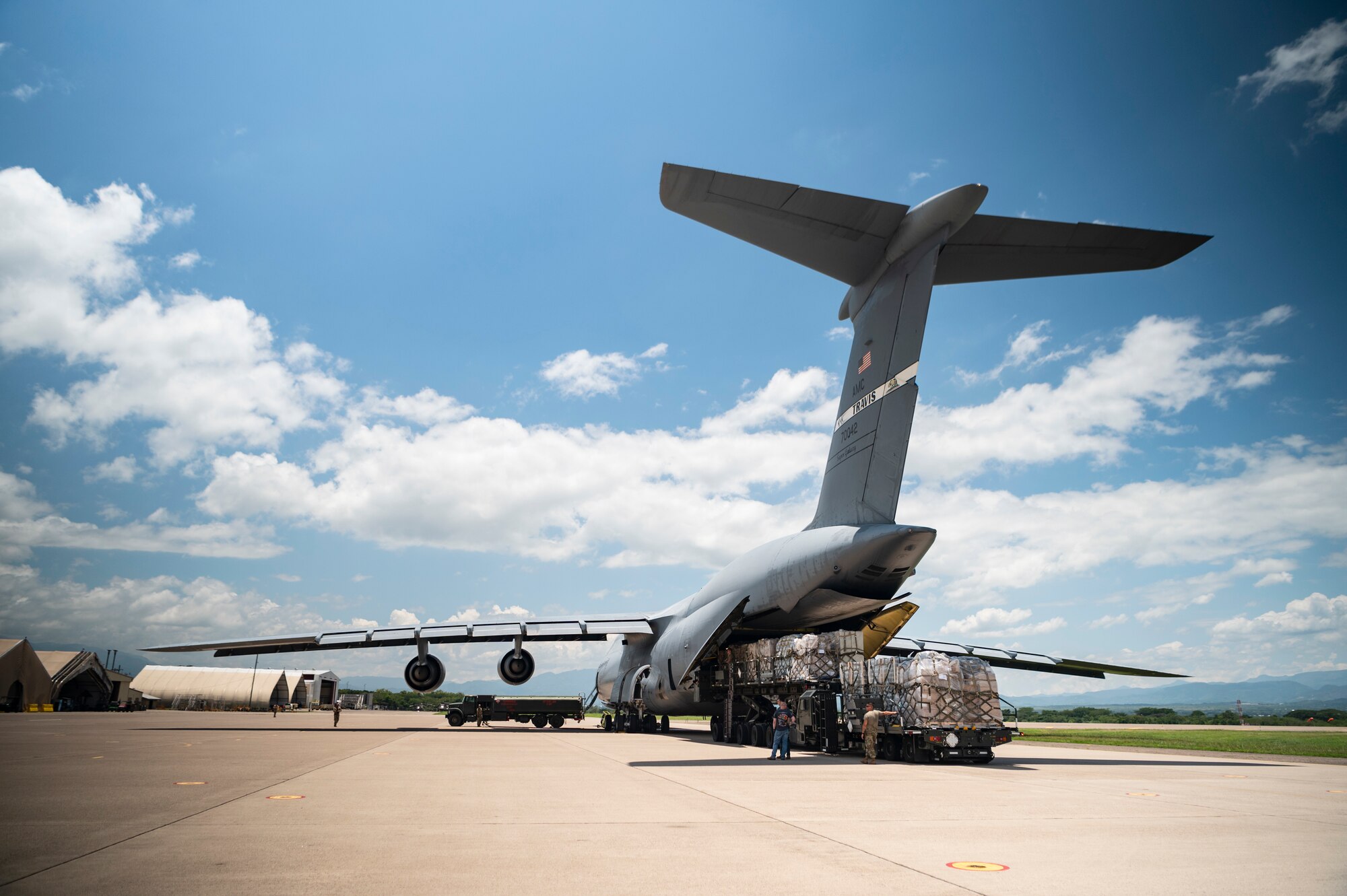 Cargo is loaded into the back of a large aircraft.