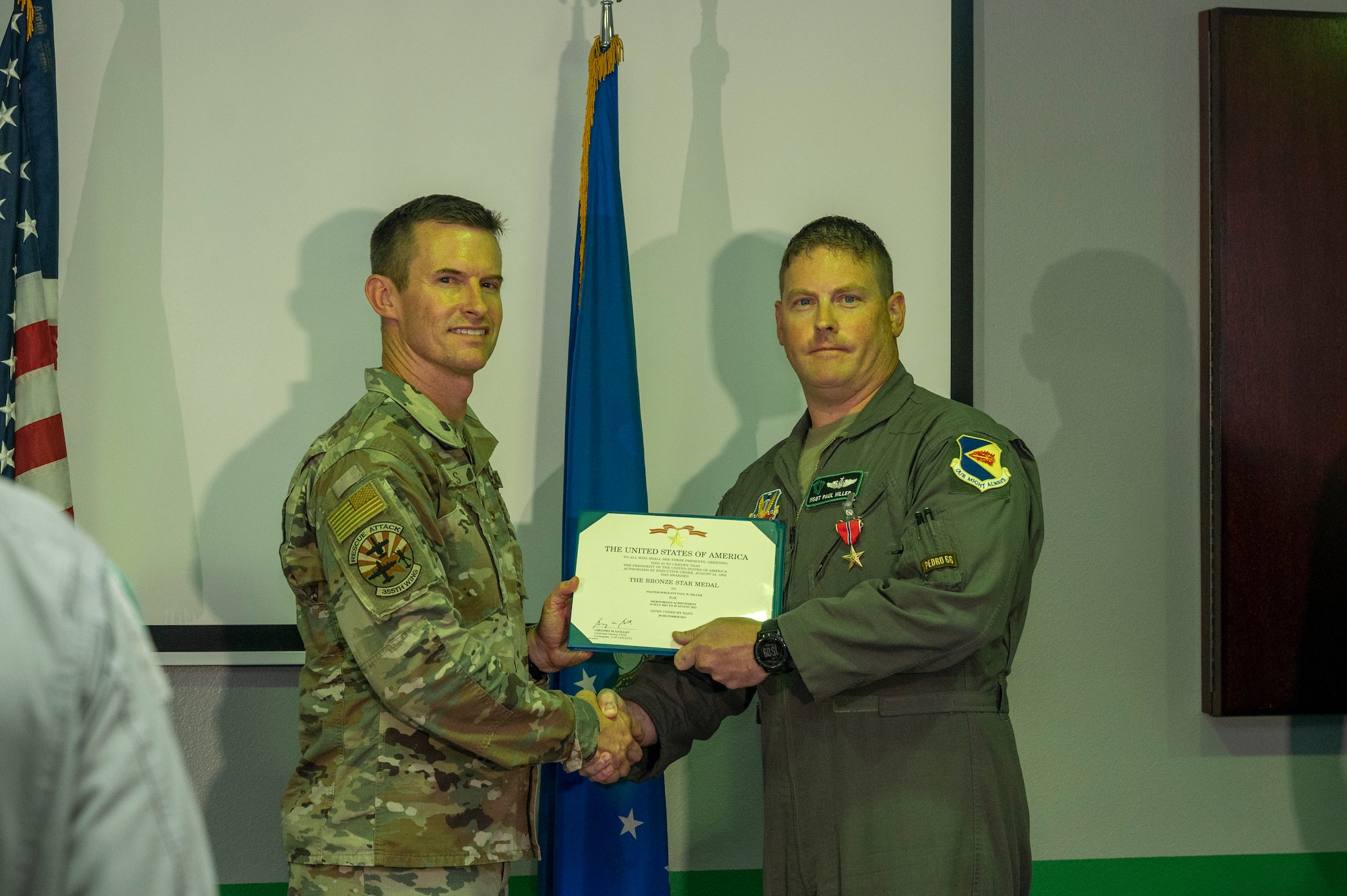 Pictured are two people holding a certificate.