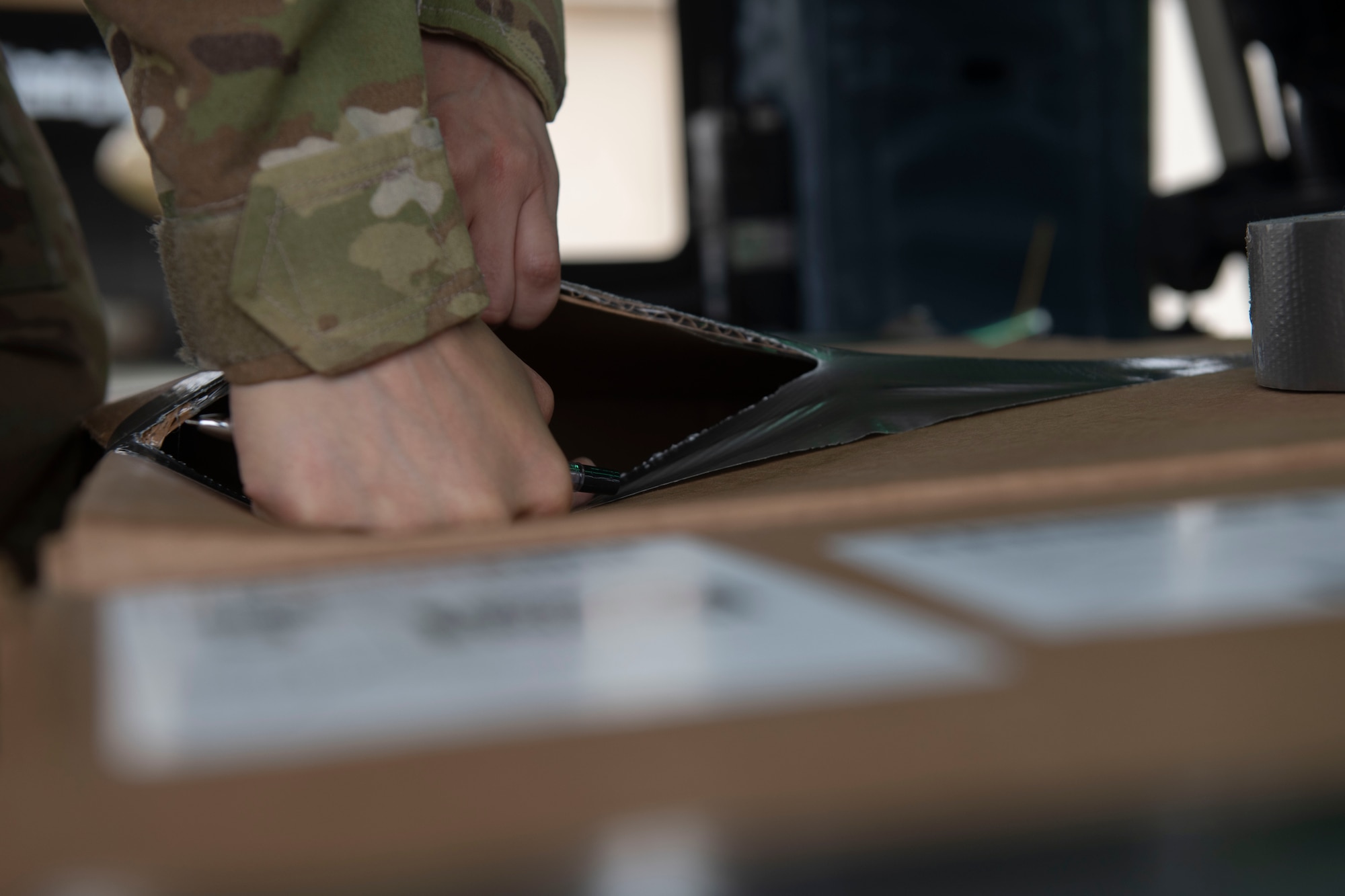 Tech. Sgt. Alexandra Vidato, 459th Airlift Squadron instructor flight engineer, opens a box of simulated humanitarian aid prior to takeoff for a Tokyo Metropolitan Government hosted disaster preparedness and response drill at Tokyo Rinkai Disaster Prevention Park, Japan, Sept. 3, 2022. This training allows the 459th AS to better integrate with the Government of Japan and respond faster during a real-world scenario. (U.S. Air Force photo by Tech. Sgt. Joshua Edwards)