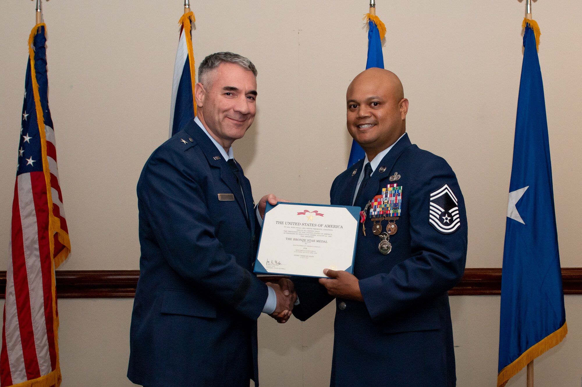 U.S. Air Force Brig. Gen. Joseph Campo, left, awards Senior Master Sgt. Jeremy Mapalo, 48th Security Forces Squadron operations superintendent, right, the Bronze Star Medal with Valor.