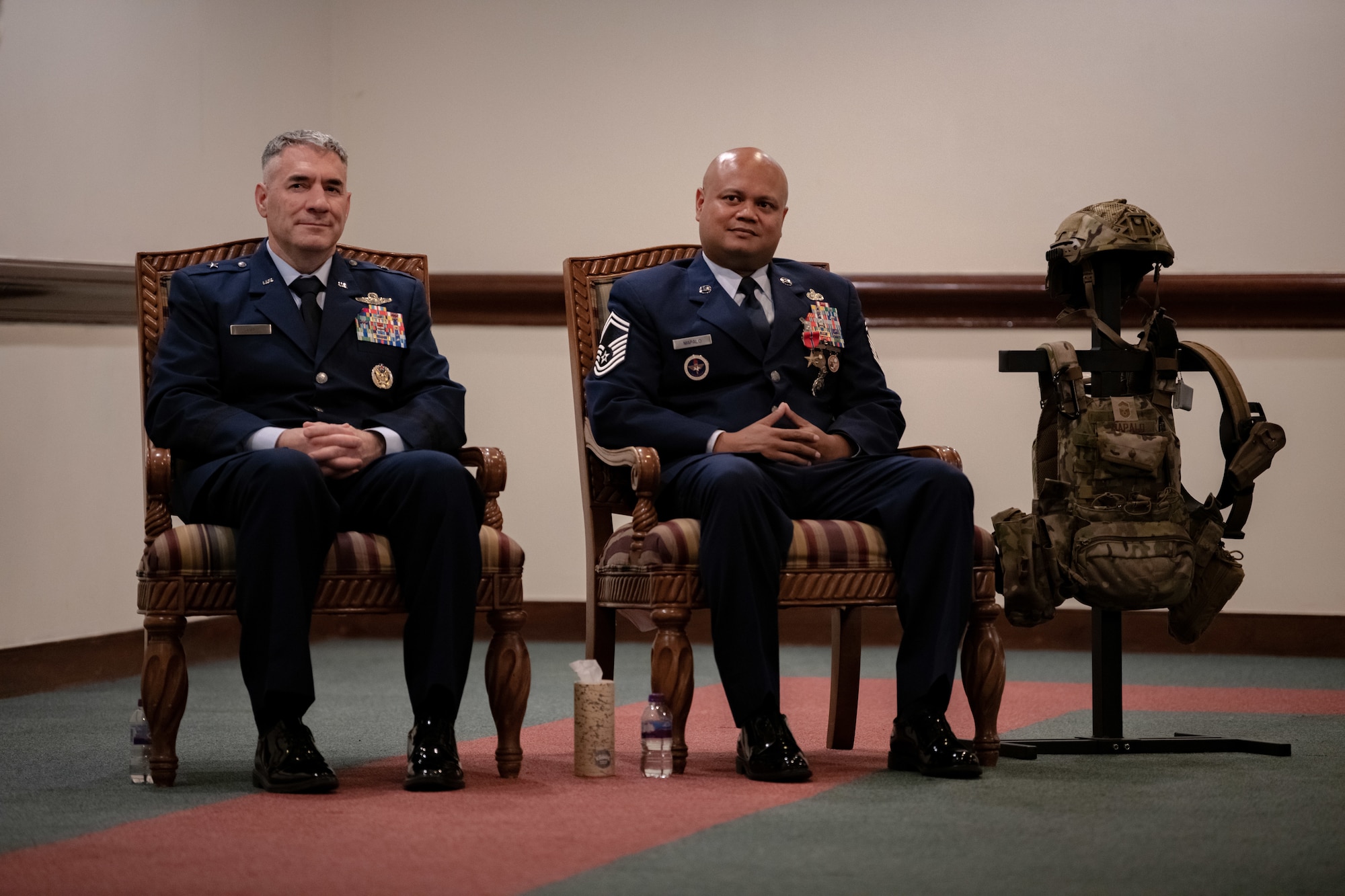 U.S. Air Force Brig. Gen. Joseph Campo, 48th Fighter Wing commander, and Senior Master Sgt. Jeremy Mapalo, 48th Security Forces Squadron operations superintendent, sit side by side during a Bronze Star presentation ceremony.