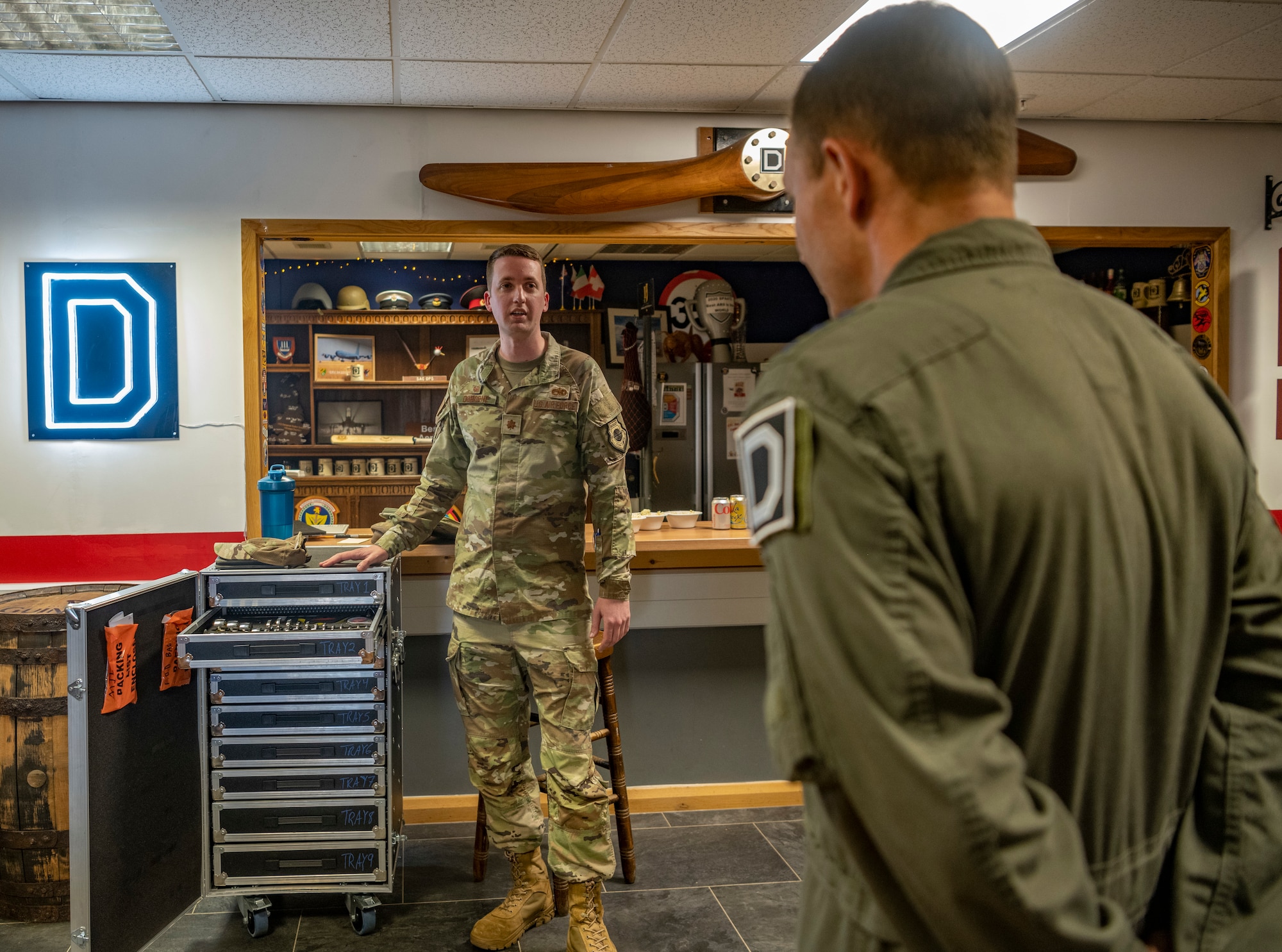 U.S. Air Force Maj. Matthew Osborne briefs on innovations maintenance Airmen built for the KC-135 Stratotanker to Lt. Gen. John D. Lamontagne