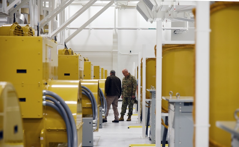 Mike Doty, electrical engineer, USACE Alaska District, takes Col. Sebastien P. Joly, Huntsville Center commander, on a tour of the generator room in the Long-Range Discrimination Radar power plant at Clear Space Force Station, Alaska, on August 16. The power plant houses seven generators, each one capable of powering a locomotive, as a back-up energy source to keep the radar active in case of power failure. (Photo by Kristen Bergeson)