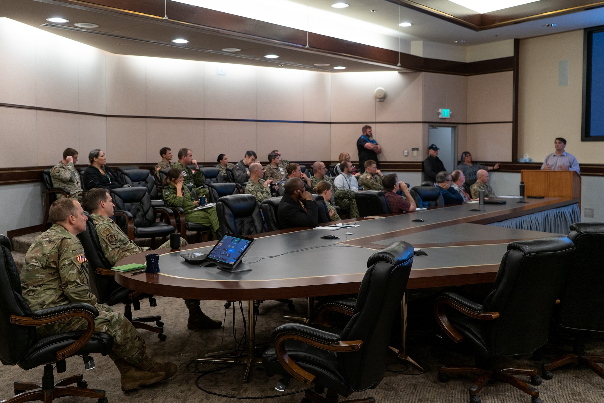 Alaskan Command staff and other participants of Arctic Resolve 2022 look towards the current speaker at the podium during the event in the Reeve's Conference Room.