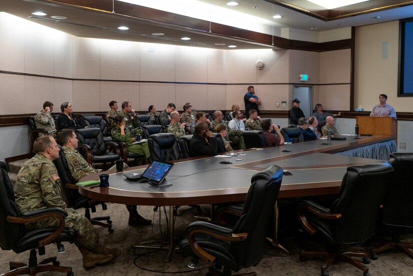 Alaskan Command staff and other participants of Arctic Resolve 2022 look towards the current speaker at the podium during the event in the Reeve's Conference Room.