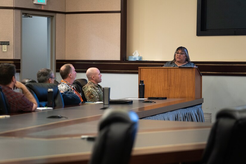 Michelle Torres speaks from a podium in front of room of Alaskan Command staff and other participants of Arctic Resolve 2022.