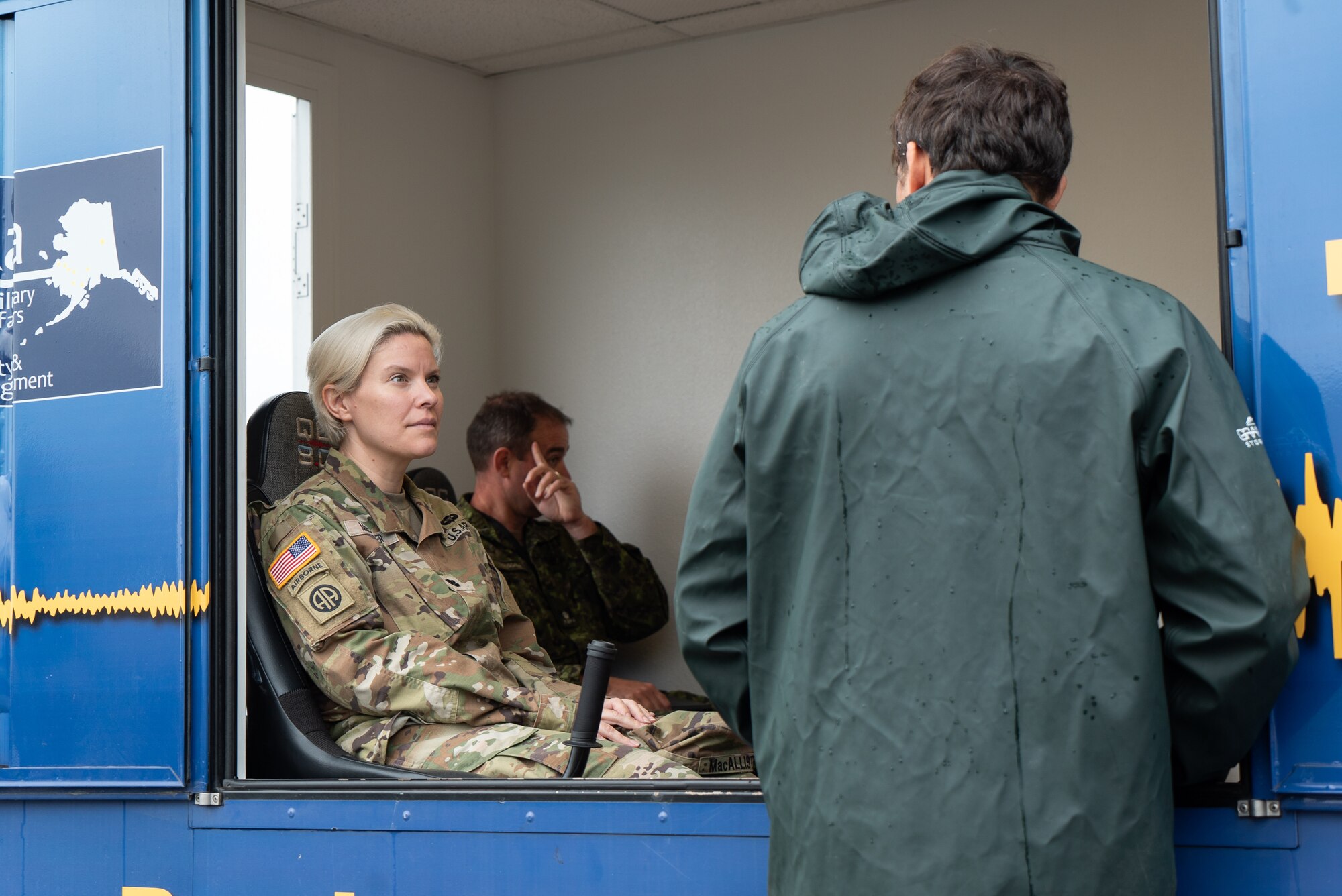 U.S. Army Lt. Col. Kate MacAllister listens to the operator of Alaska's Earthquake Simulator explain the specifics of the simulation.