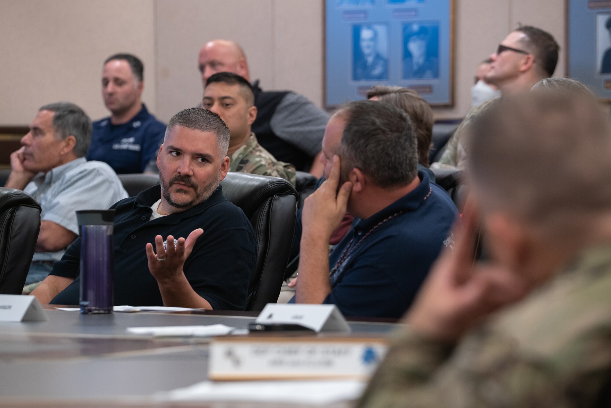 Scott Zaffram talks to other individuals sitting at a conference room table.