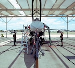 Crew chiefs from the 149th Maintenance Group perform a landing gear swings operations check on an F-16 Fighting Falcon.