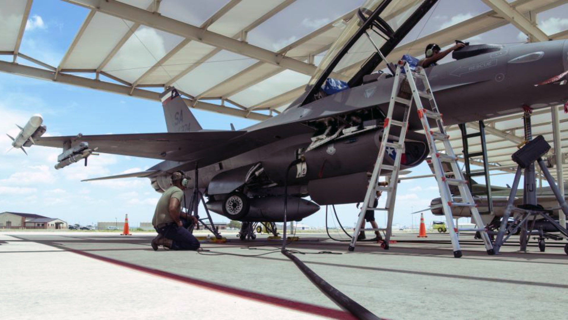 Crew chiefs from the 149th Maintenance Group perform a landing gear swings operations check on an F-16 Fighting Falcon.