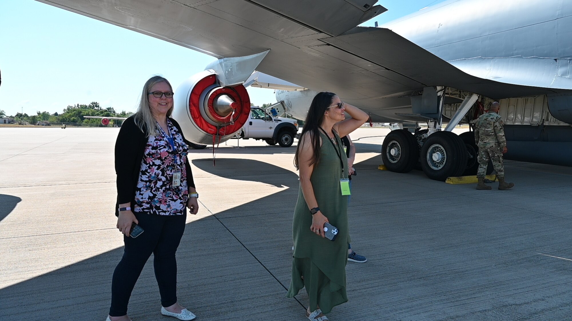 people stand under the wing of a plane