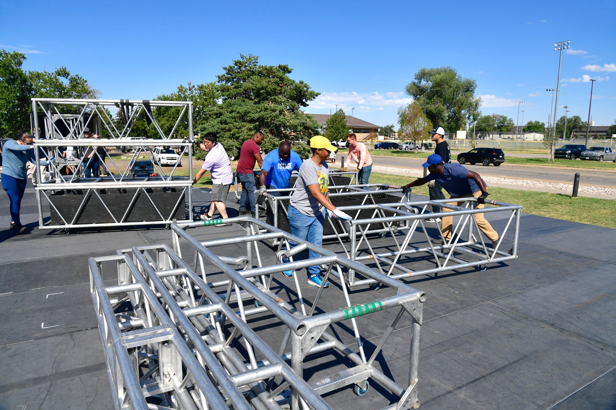 Volunteers assist Air Force Entertainment Service workers while setting up the rock festival concert stage Aug. 26, 2022, at Hill Air Force Base, Utah. The annual concert is held to boost morale and resiliency for the military and civilian workforce and their families, and was coordinated by the 75th Force Support Squadron through the Air Force Entertainment Service. (U.S. Air Force photo by Todd Cromar)