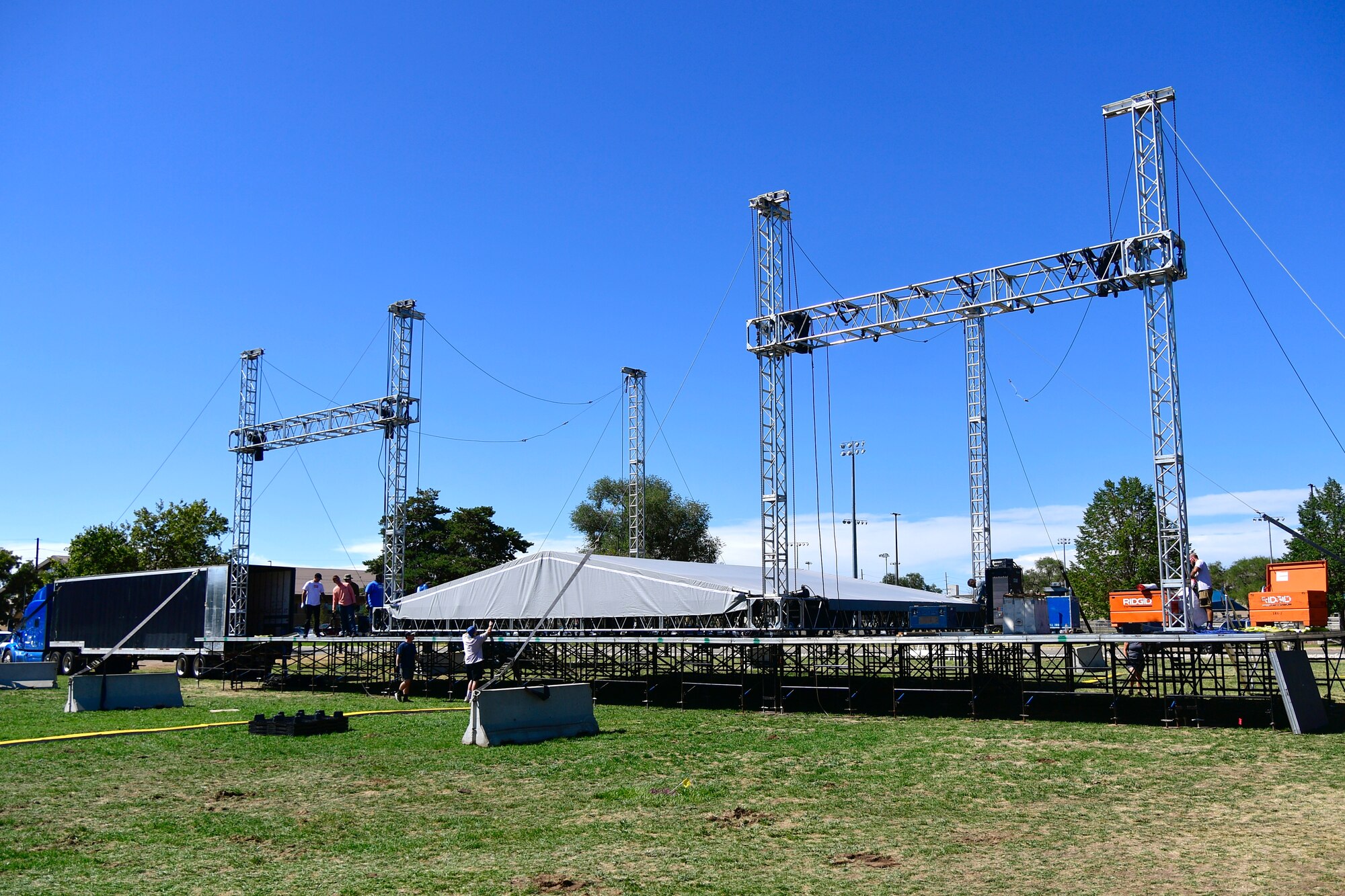 Volunteers assist Air Force Entertainment Service workers while setting up the rock festival concert stage Aug. 26, 2022, at Hill Air Force Base, Utah. The annual concert is held to boost morale and resiliency for the military and civilian workforce and their families, and was coordinated by the 75th Force Support Squadron through the Air Force Entertainment Service. (U.S. Air Force photo by Todd Cromar)