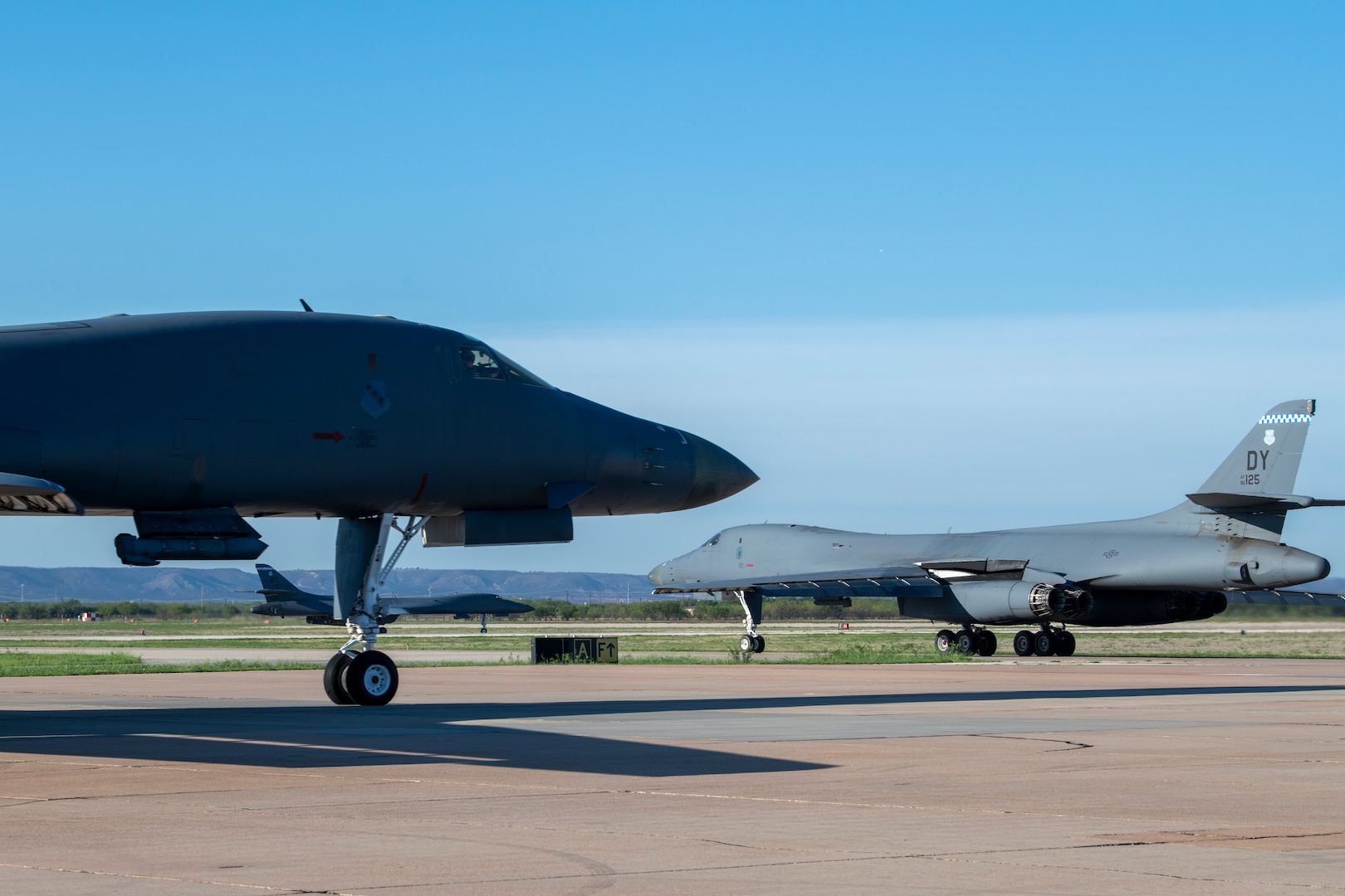 Three B-1B Lancers prepare to takeoff at Dyess Air Force Base, Texas Sept. 7th, 2022. The U.S. Strategic Command routinely conducts Bomber Task Force operations across the globe with and in support of the Geographic Combatant Commands. (U.S. Air Force photo by Senior Airman Mercedes Porter)