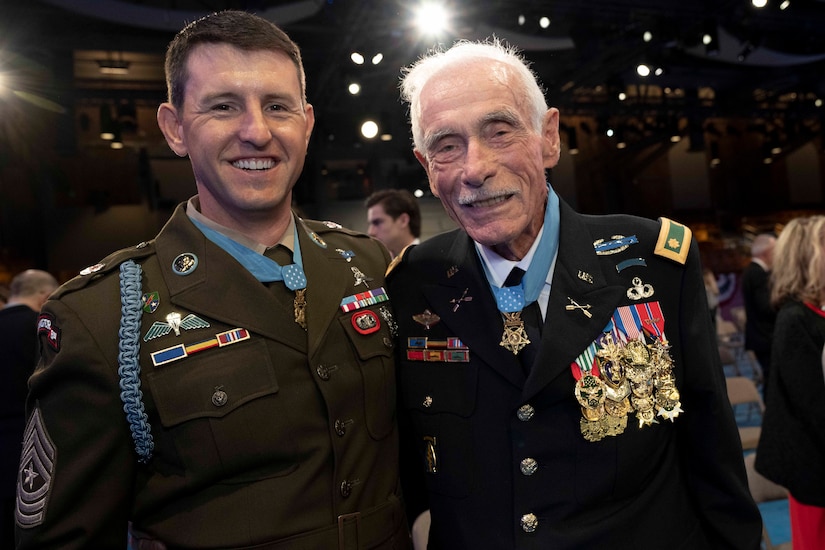 Two men in uniform poses together for a photo.