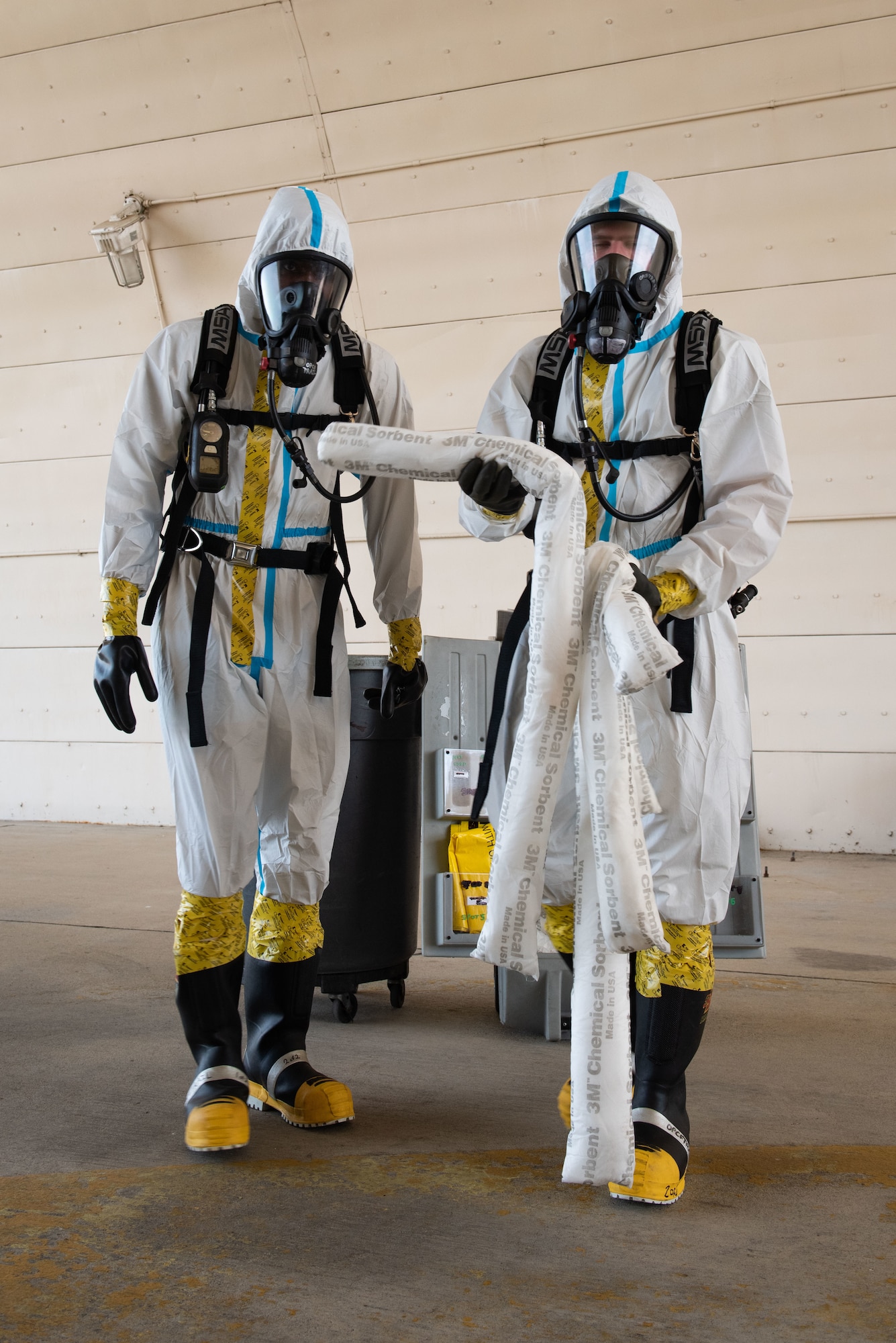 Senior Airman Dontarious Baker and Senior Airman Troy Daniel, 51st Maintenance Squadron aircraft fuel systems journeymen, grab material to absorb a simulated hydrazine fuel spill during a training at Osan Air Base, Republic of Korea, Aug. 26, 2022.