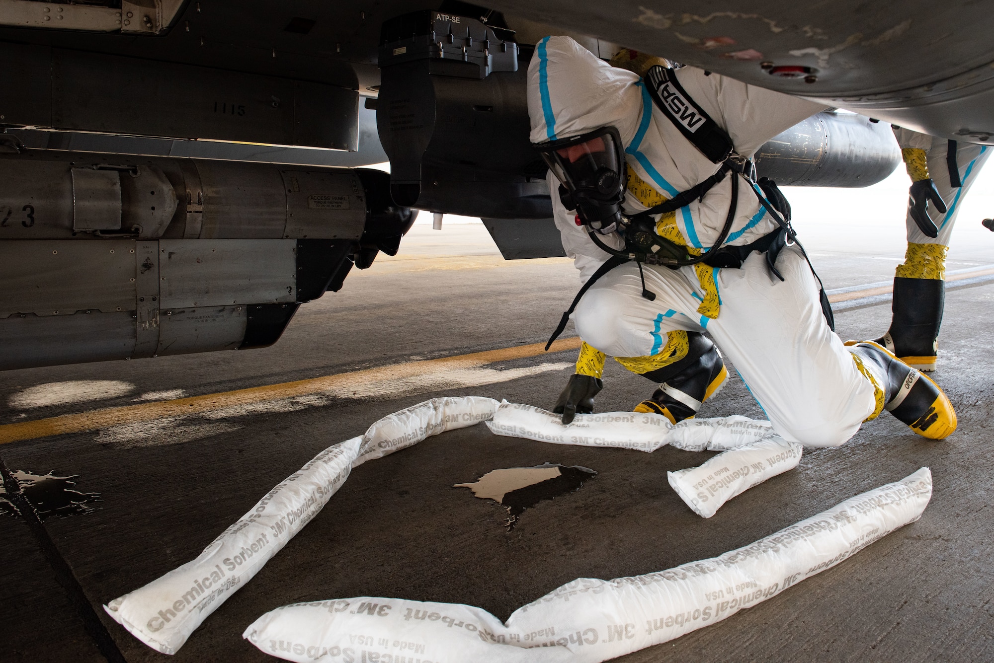 Senior Airman Troy Daniel, 51st Maintenance Squadron aircraft fuel systems journeyman, lays down chemical absorbent material to contain simulated hydrazine fuel during a training at Osan Air Base, Republic of Korea, Aug. 26, 2022.