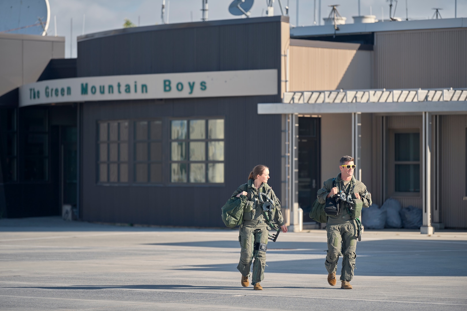 A photo of 1st Lt. Kelsey Flannery, an F-35A Lightning II pilot, and Capt. Jake Dubie, an instructor pilot, both assigned to the 134th Fighter Squadron of the Vermont Air National Guard's 158th Fighter Wing, head to their jets for a training mission from South Burlington Air National Guard Base, Vermont, Sept. 7, 2022. Flannery, who is the Air National Guard's first female F-35 pilot, made her first flight with the 158th after returning from three years of flight training. (U.S. Air National Guard photo by Master Sgt. Ryan Campbell)