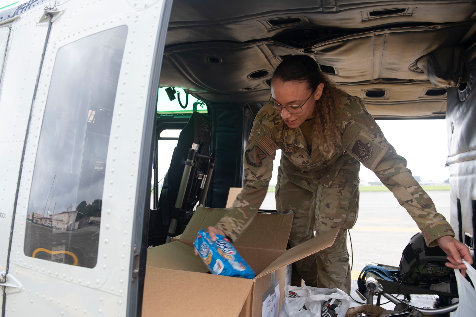 Tech. Sgt. Alexandra Vidato, 459th Airlift Squadron instructor flight engineer, adds supplies to a box of simulated humanitarian aid prior to takeoff for a Tokyo Metropolitan Government hosted disaster preparedness and response drill at Tokyo Rinkai Disaster Prevention Park, Japan, Sept. 3, 2022. Taking off from Yokota Air Base, the 459th utilized a UH-1N Iroquois helicopter to deliver mock humanitarian aid after a simulated natural disaster. (U.S. Air Force photo by Tech. Sgt. Joshua Edwards)