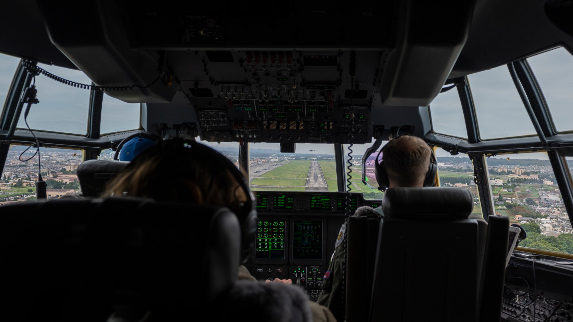 Inside a cockpit close to landing, can see the runways out the forward windows.