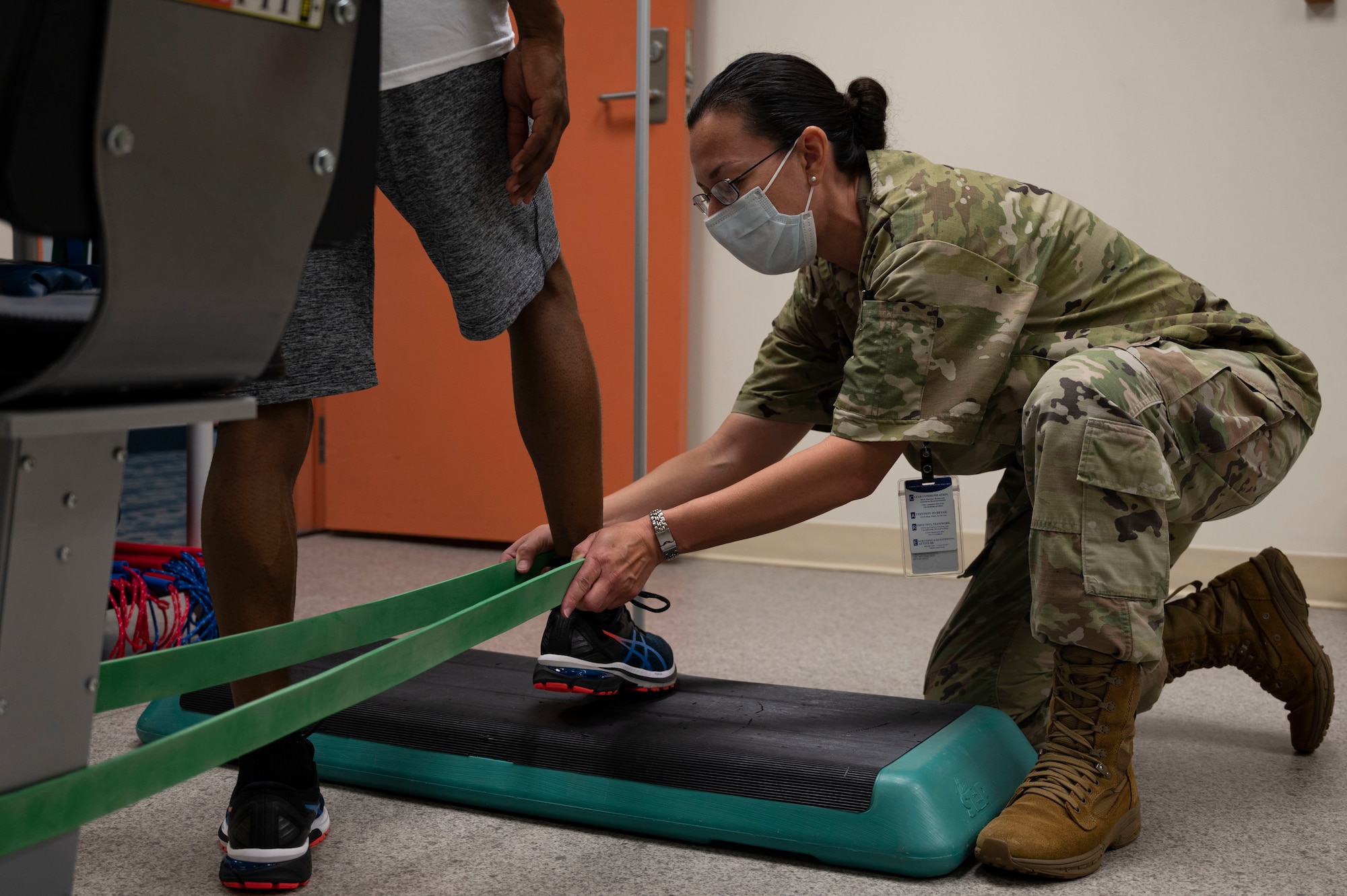 U.S. Air Force Staff Sgt. Monica Rivera, 36th Medical Group Physical Therapy Clinic noncommissioned officer in charge, assists a patient with putting on a TheraBand before performing closed kinetic chain ankle mobilization exercises at the PT Clinic on Andersen Air Force Base, Guam, Sept. 7, 2022. A customized PT plan helps ensure a patient's return to prior level of functioning so they can contribute to the mission to the best of their ability. (U.S. Air Force photo by Airman 1st Class Lauren Clevenger)