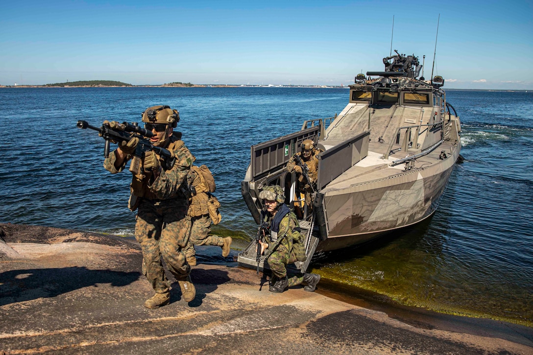 U.S. Marines with Golf Company, Battalion Landing Team 2/6, 22nd Marine Expeditionary Unit (MEU), disembark a Finnish U700 Jehu- class amphibious assault craft during an island seizure exercise on Russaro Island, Finland, Aug. 12, 2022. The Kearsarge Amphibious Ready Group and embarked 22nd MEU, under the command and control of Task Force 61/2, is on a scheduled deployment in the U.S. Naval Forces Europe area of operations, employed by U.S. Sixth Fleet to defend U.S., allied and partner interests.  (U.S. Marine Corps photo by Sgt. Armando Elizalde)