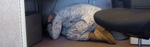 Corporal Michael Austin, a clerk at the finance office, ducks and covers under his desk during the Great ShakeOut earthquake exercise drill, Oct. 18, 2012. The American Red Cross recently led another nationwide Great ShakeOut drill, Oct. 17, with more than 15,000 people in Hawaii registered to participate.
