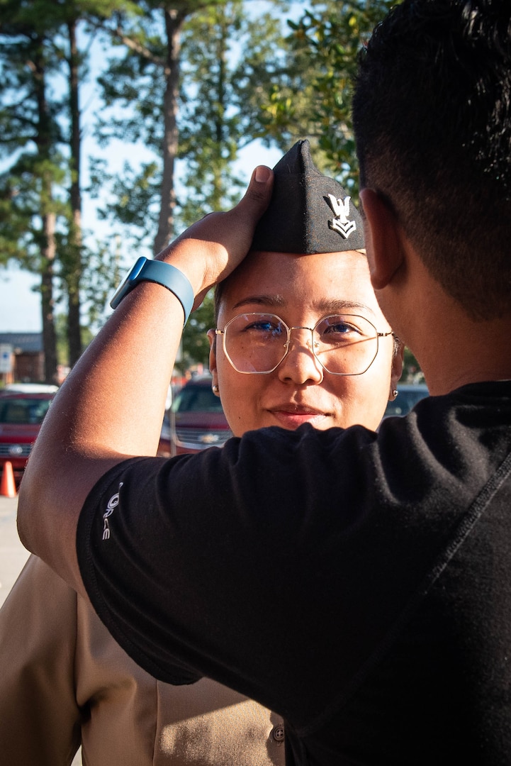 Hospital Corpsman Second Class Saleela Suwannarak advances rank during a ceremony held aboard Naval Health Clinic Cherry Point during a ceremony held Friday, September 9.  Her husband, Inmar, pinned her new rank upon her Garrison Cap.