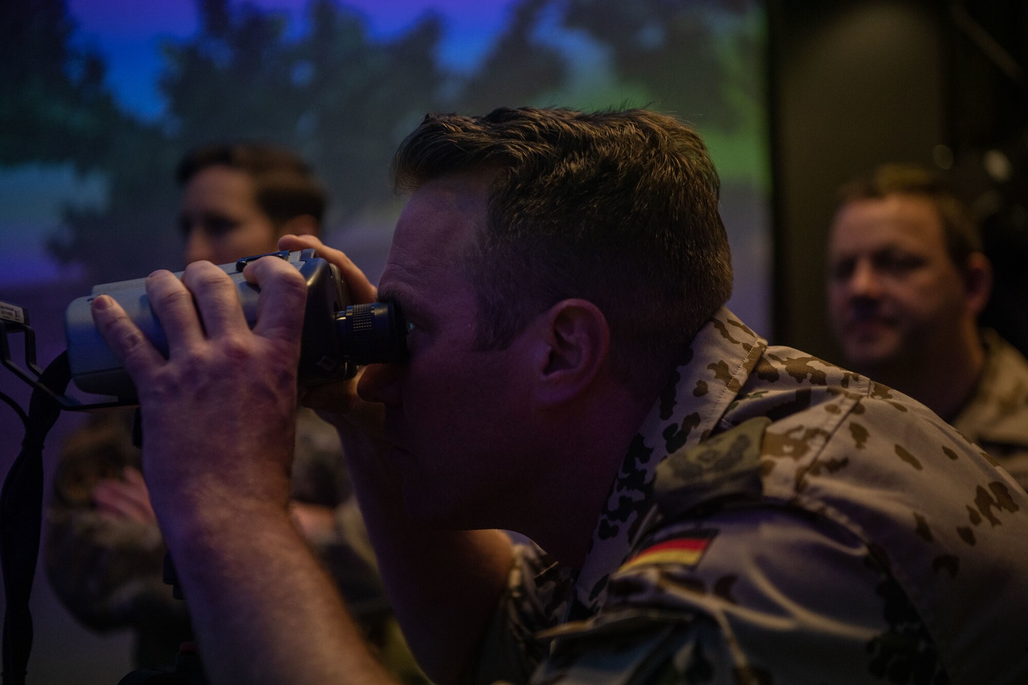 a man peers through binoculars