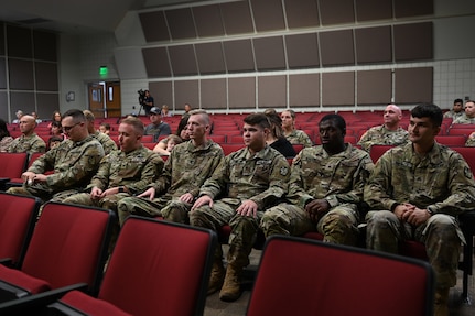 Deploying Soldiers listen to a speaker during their deployment ceremony.