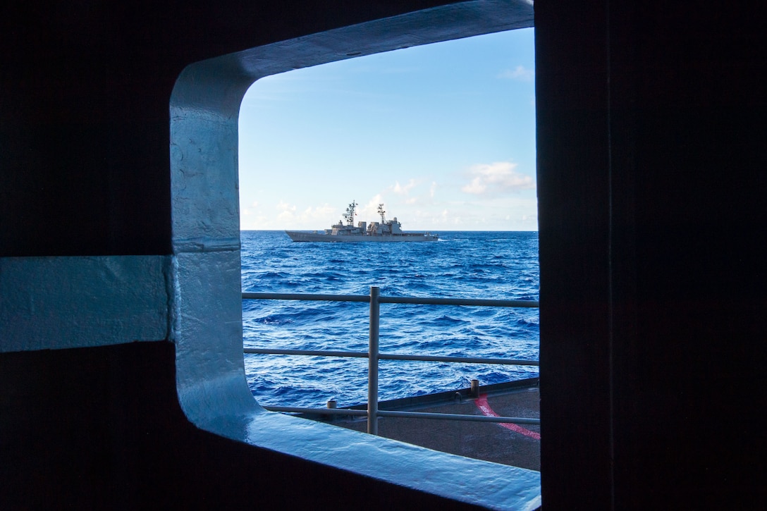 A ship is seen through another ship's porthole.