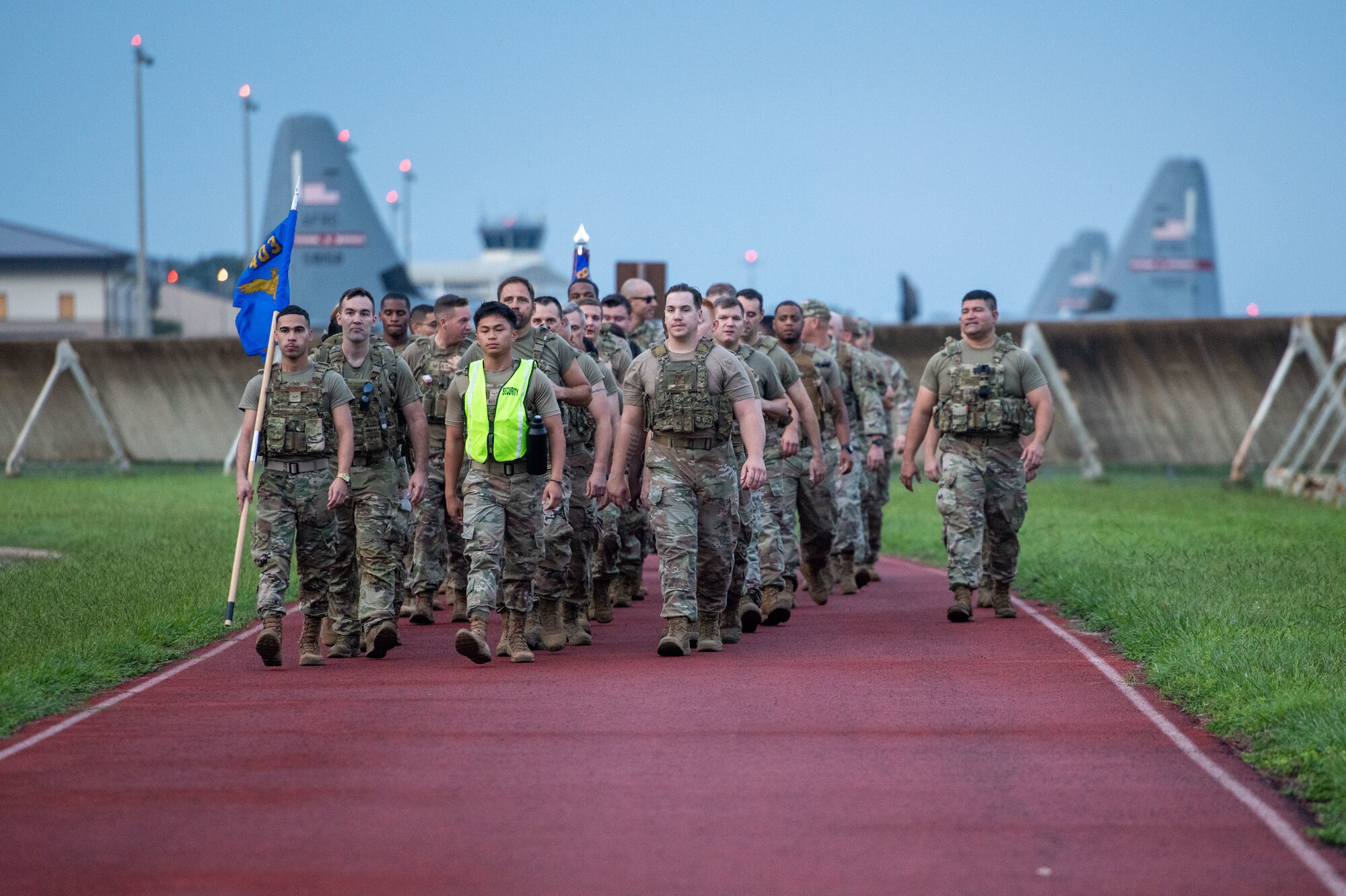 Members of the 403rd Security Forces Squadron march at ease. Tails from C-130J aircraft are seen in the background