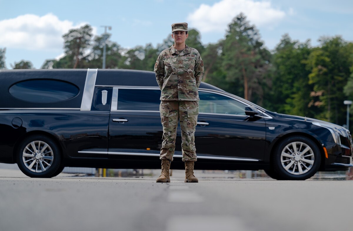 Master Sgt. Angela Purington, Air Force Mortuary Affairs Operations Operating Location-Europe command mortuary affairs manager, stands in front of a hearse at Ramstein Air Base, Germany Aug. 15, 2022. AFMAO OL-E provides mortuary support to the seven main operating bases in U.S. Air Forces Europe and Air Forces-Africa and serves as subject matter experts to support base-level programs. (U.S. Air Force photo by Airman 1st Class Edgar Grimaldo)
