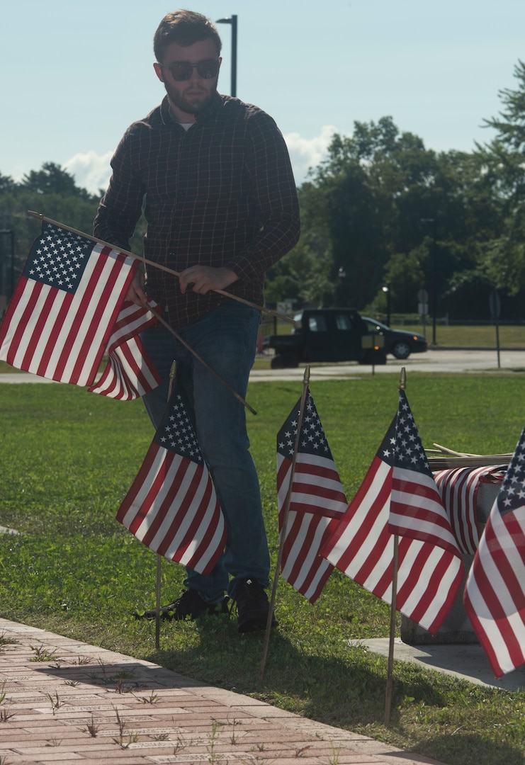 John Brutzman, the substance abuse prevention coordinator for the Vermont National Guard, plants flags in front of the Vermont Veterans Memorial at Camp Johnson, Vermont, on Sept. 8, 2022. Brutzman, a native of Montclair, New Jersey, also serves as a suicide prevention coordinator. (U.S. Army National Guard photo by Don Branum)