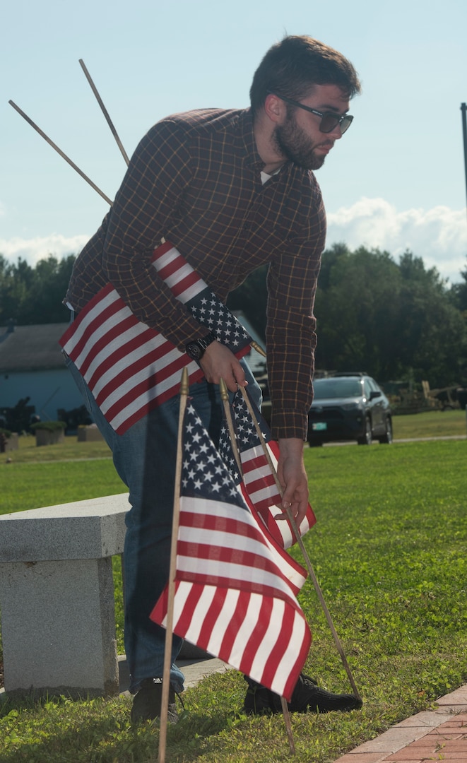 John Brutzman, the substance abuse prevention coordinator for the Vermont National Guard, plants flags in front of the Vermont Veterans Memorial at Camp Johnson, Vermont, on Sept. 8, 2022. Brutzman, a native of Montclair, New Jersey, also serves as a suicide prevention coordinator. (U.S. Army National Guard photo by Don Branum)