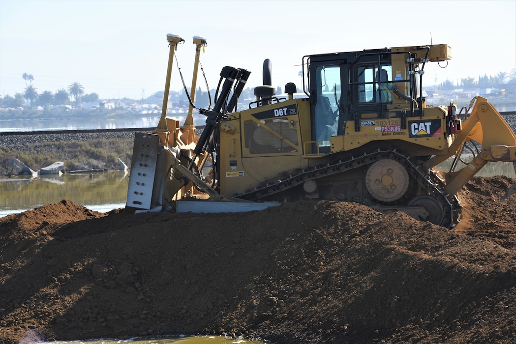 construction machinery moving dirt near water