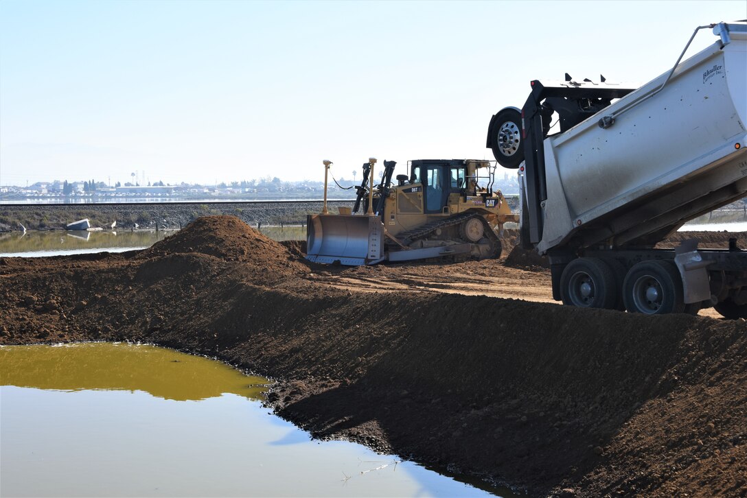 construction machinery moving dirt near water