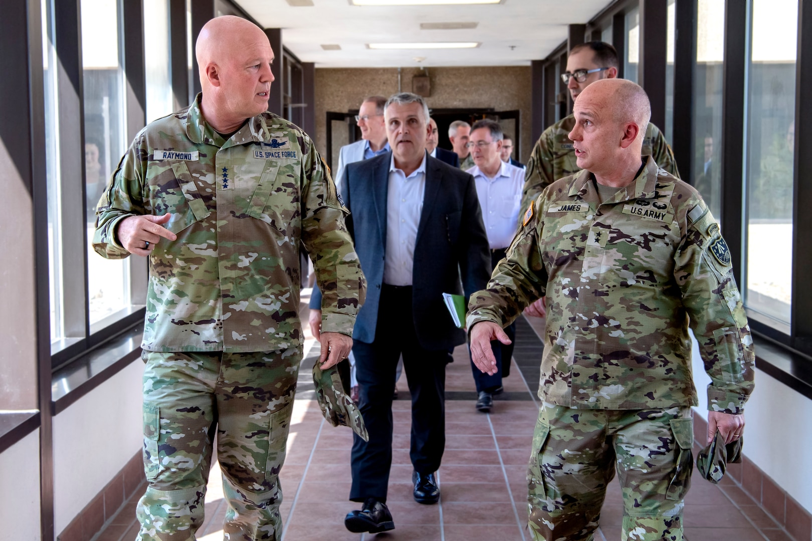 Two military men in uniform walking down a hallway