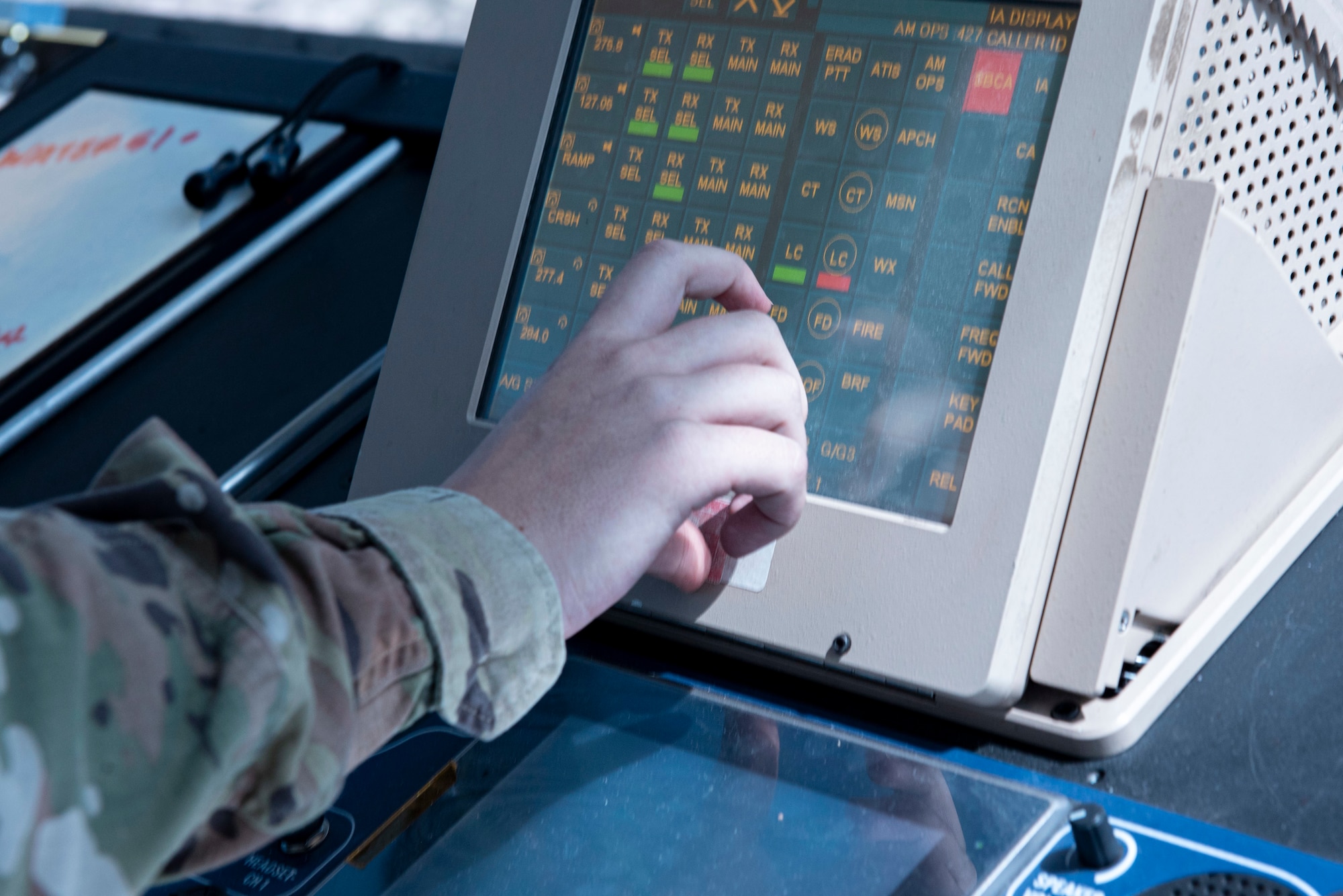 A person is getting ready to tap onto the screen of a computer filled with different channels.