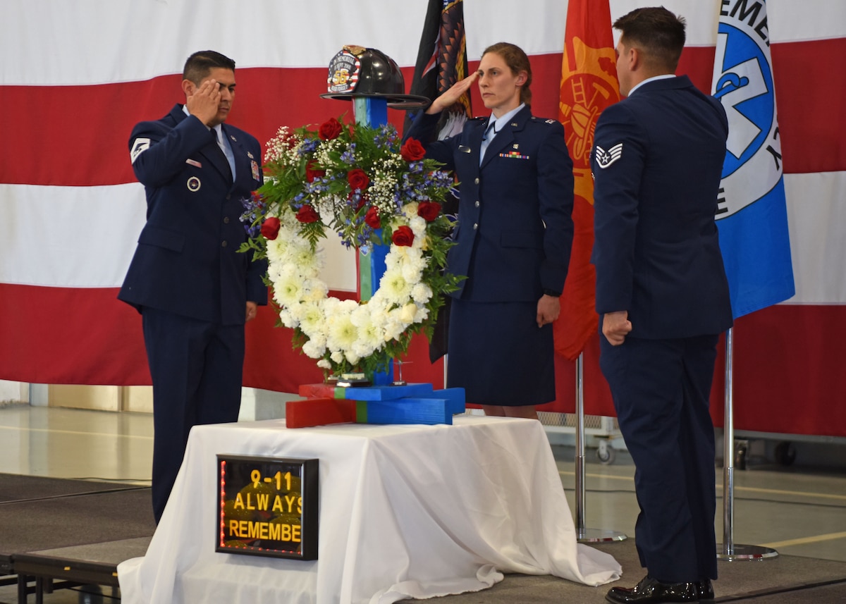 U.S. Air Force Chief Master Sgt. Robert Laning, 312th Training Squadron senior enlisted leader (left); Capt. Andrea Shefferly, 17th Operation Medical Readiness Squadron physical therapy and optometry flight commander (middle); and Staff Sgt. Michael Stanton, 17th Security Forces Squadron Defender (right); salute the wreath during the 312th TRS 9/11 memorial ceremony at the Louis F. Garland Department of Defense Fire Academy high bay, Goodfellow Air Force Base, Texas, Sept. 9, 2022. The colors of the wreath represent the nation, but also the first responders who selflessly served with honor and valor.  (U.S. Air Force photo by Senior Airman Ethan Sherwood)