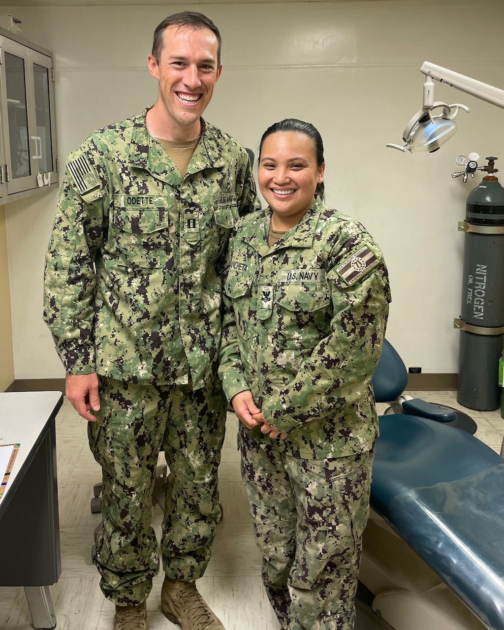 Navy Lt. Justin Odette, left, and Logistics Specialist 2nd Class Dianne Ancheta pose aboard USS Theodore Roosevelt (CVN 71) after delivery of her 3D printed dental prosthetics, July 28, 2022. (Courtesy photo/ U.S. Navy)